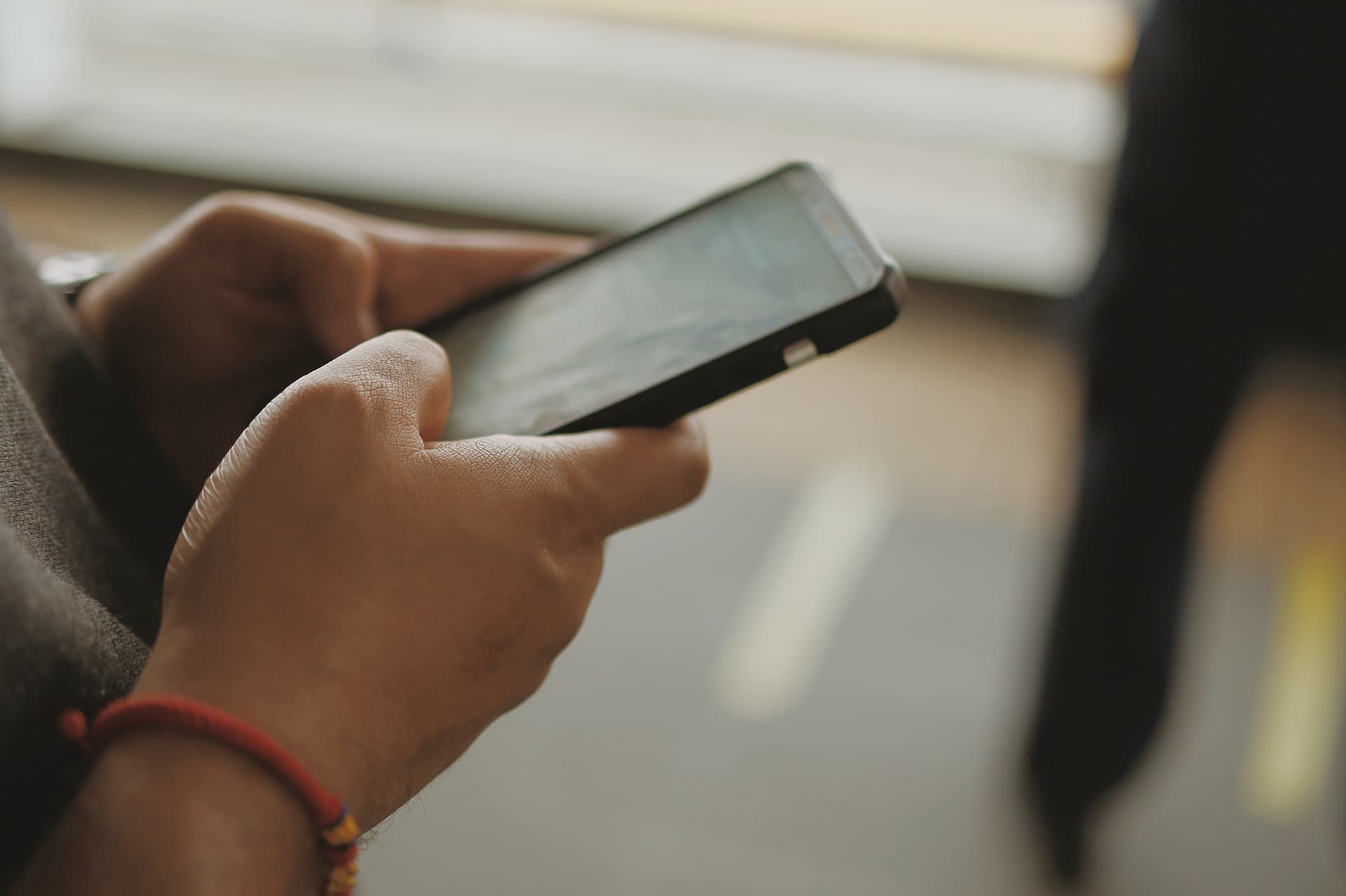 Person holding phone, close up of hands.