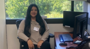 Medical assistant Maria Moreno sitting in front of a window in her office